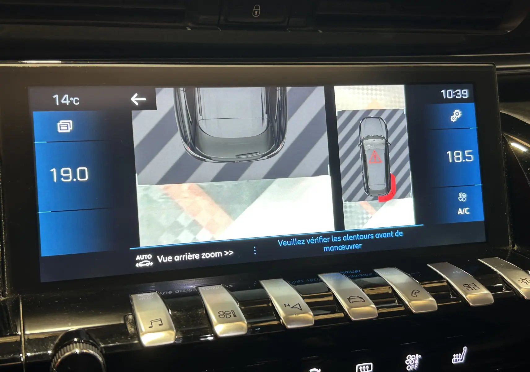 Écran tactile intérieur montrant la caméra 360° et l'affichage du véhicule gris Platinium en vue aérienne.