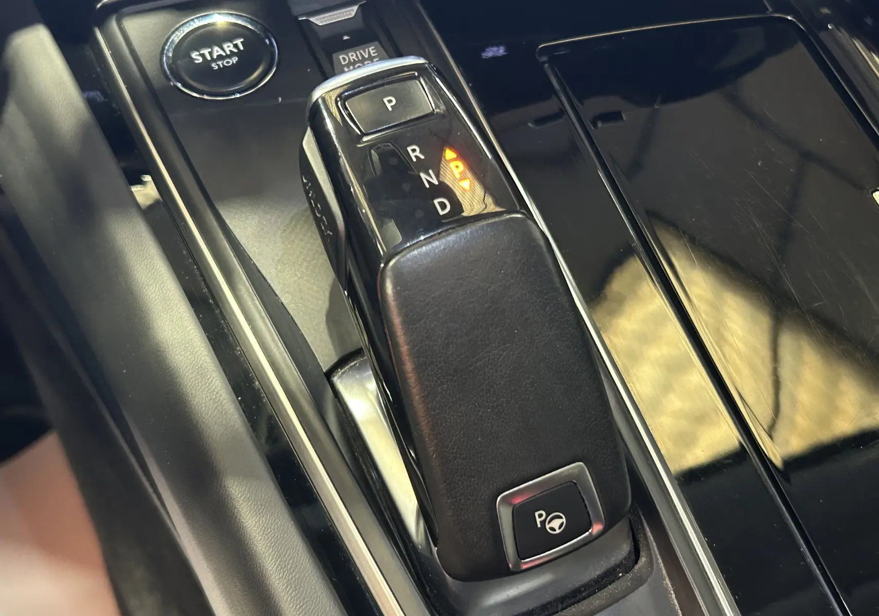 Gros plan sur la console centrale noire du Peugeot 508 SW avec levier de vitesse automatique et bouton Start/Stop.