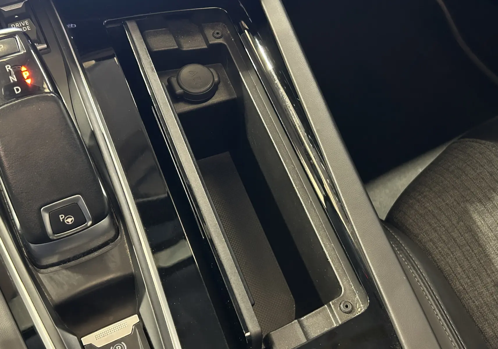 Vue rapprochée de la console centrale noire avec levier de vitesses et prise 12V du Peugeot 508 SW Gris Platinium.