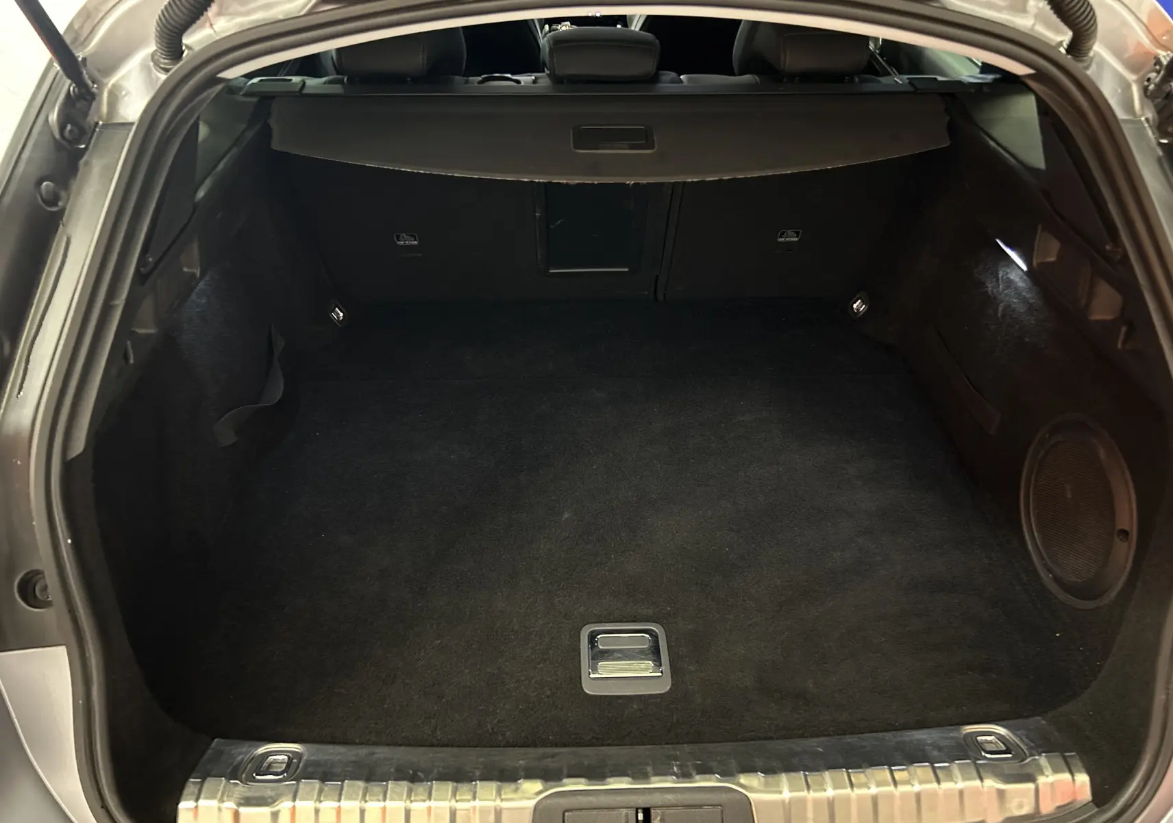 Coffre ouvert de la Peugeot 508 SW gris Platinium, montrant un espace de chargement propre et bien fini.