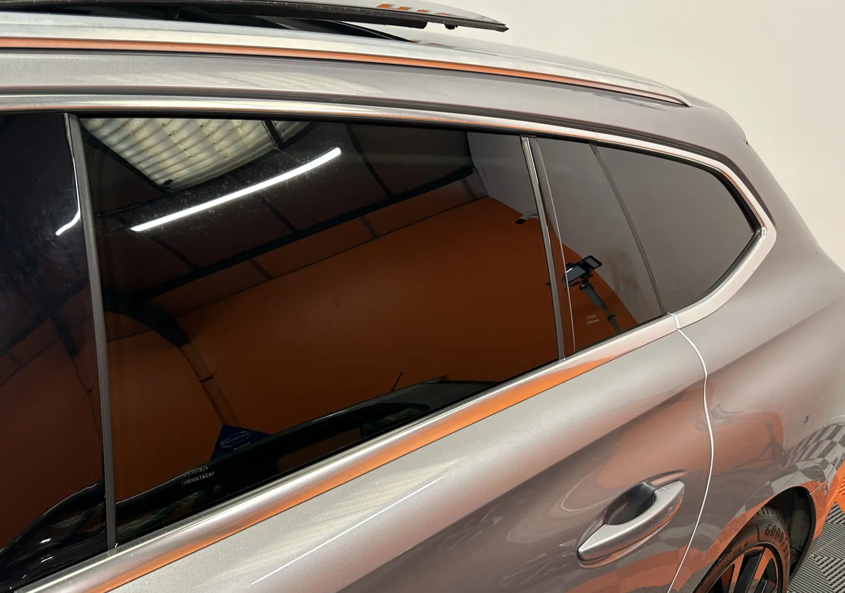 Vue latérale droite sur la porte arrière gris Platinium du Peugeot 508 SW avec vitre teintée et cadre chromé.