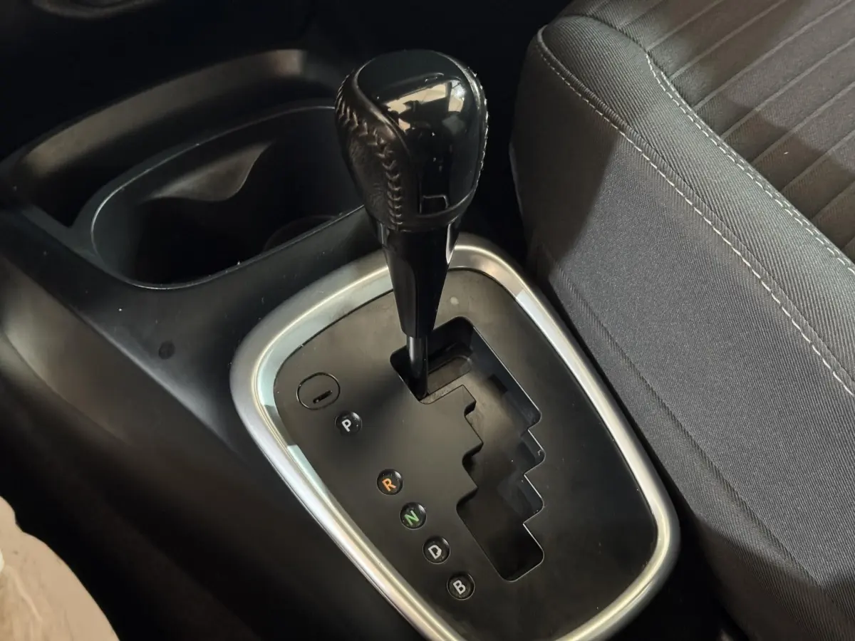 Gros plan sur la commande de boîte automatique noire de la Toyota Yaris hybride 2019, avec siège tissu gris à côté.