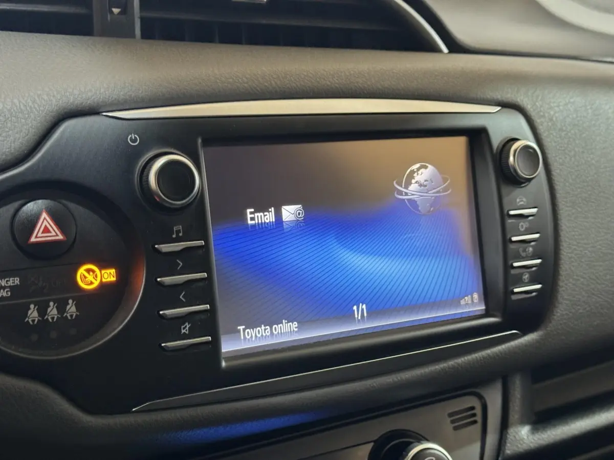Écran tactile central allumé montrant l'interface Toyota online, entouré de boutons de commande noirs.