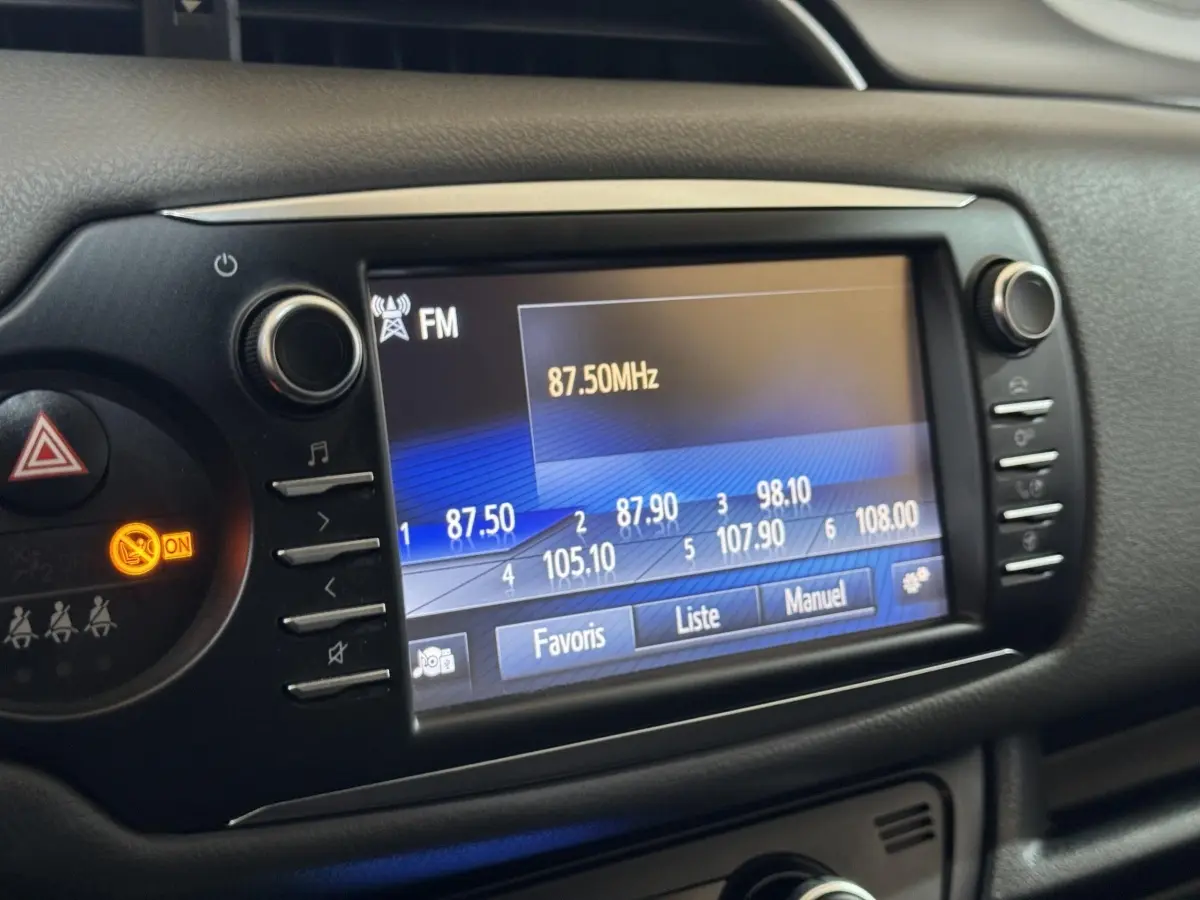 Écran tactile central de la Toyota Yaris 1.5 Hybrid 2019 affichant la radio FM à 87,50 MHz, vue rapprochée intérieure.