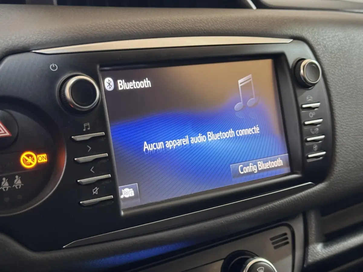 Écran tactile central affichant la connexion Bluetooth dans l’habitacle noir d’une Toyota Yaris hybride 2019.