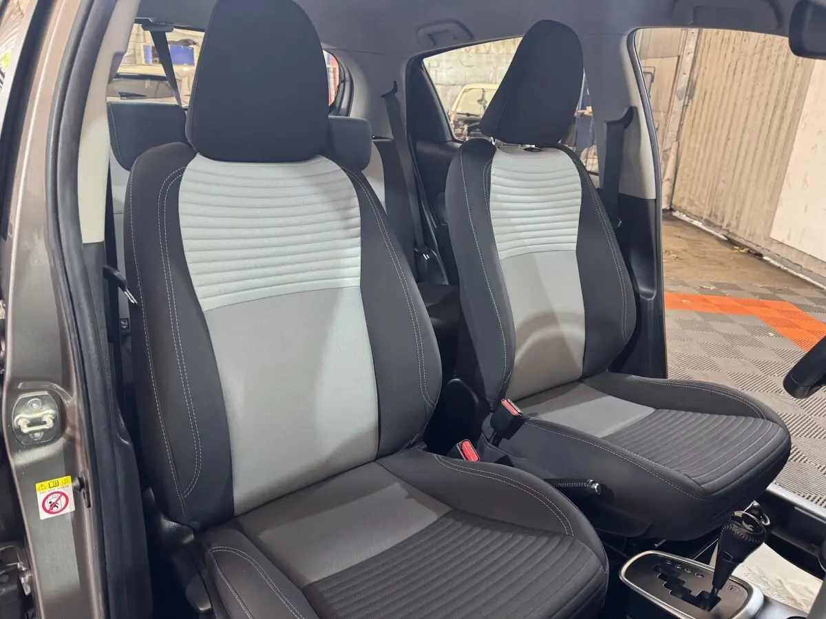 Vue intérieure sur les sièges avant gris clair et foncé de la Toyota Yaris 1.5 Hybrid 2019 avec boîte automatique.