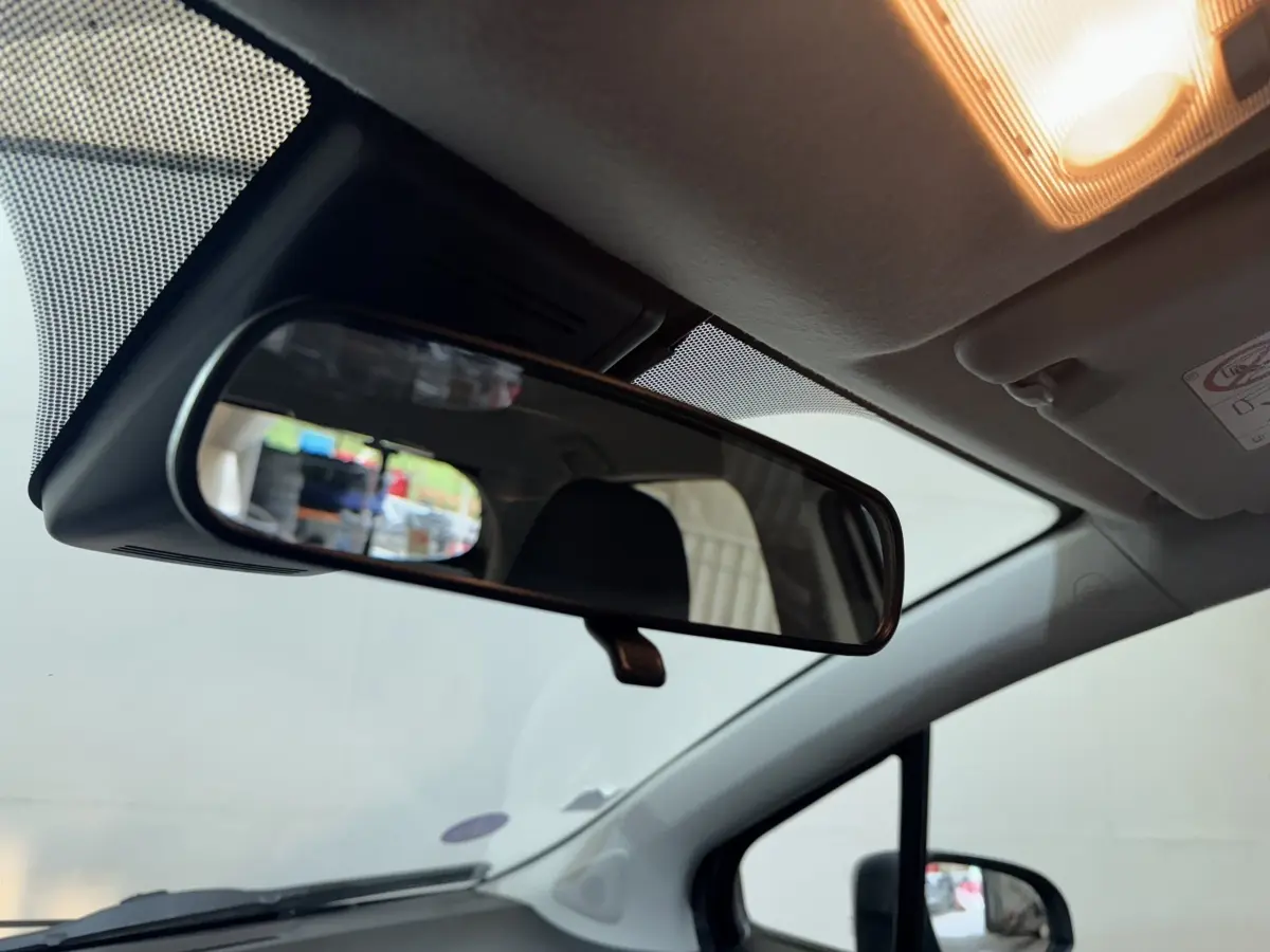 Vue intérieure du rétroviseur central d'une Toyota Yaris 1.5 VVT-I Hybrid 2019, avec plafond clair et lumière allumée.