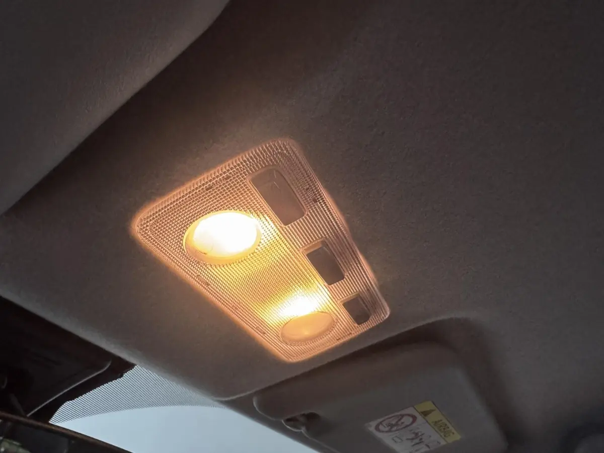 Plafonnier intérieur allumé de la Toyota Yaris 1.5 VVT-I Hybrid 2019, vue du plafond cabine en gris foncé.