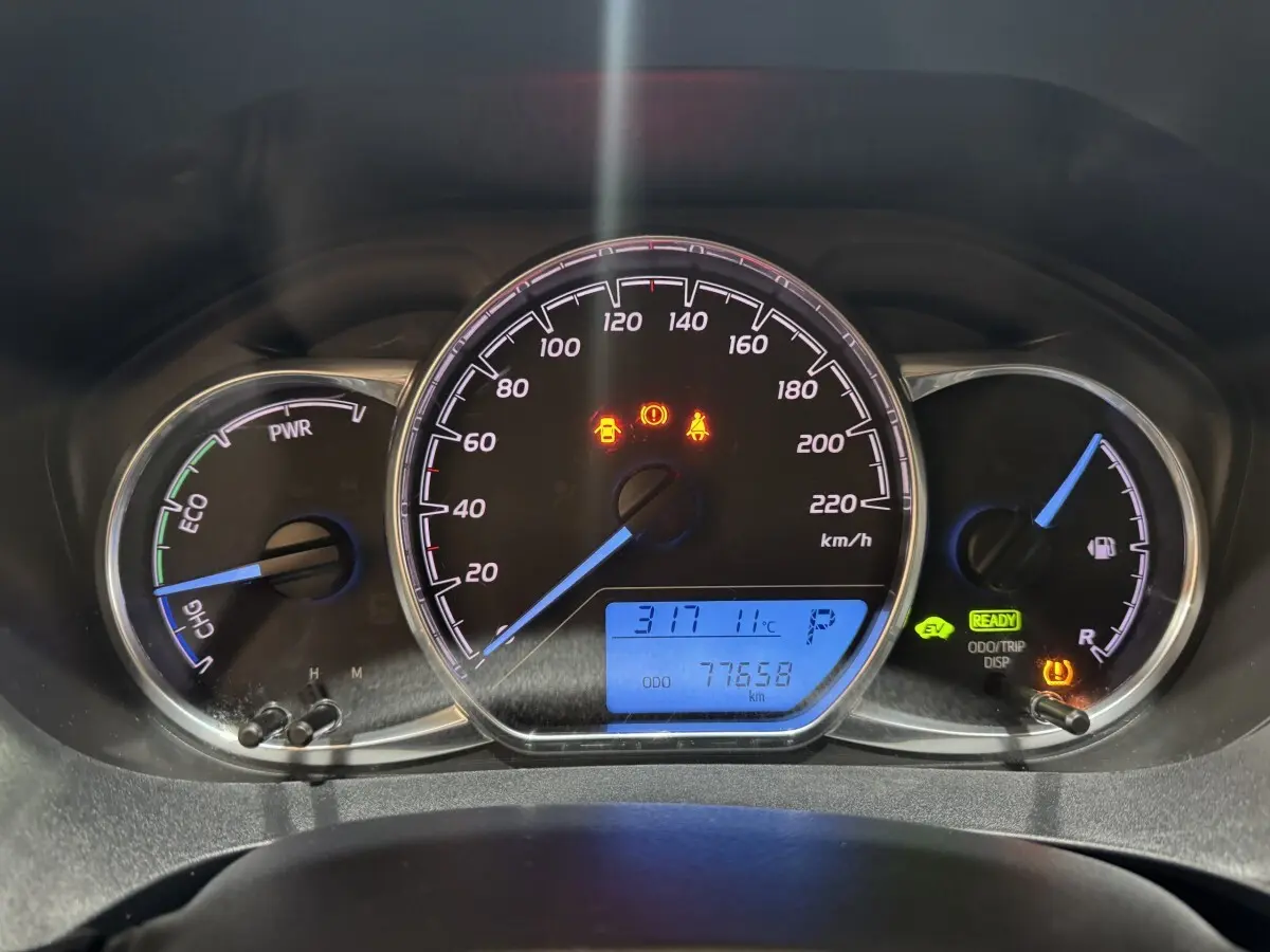 Vue rapprochée du tableau de bord de la Toyota Yaris hybride 2019, affichage digital bleu et voyants allumés.