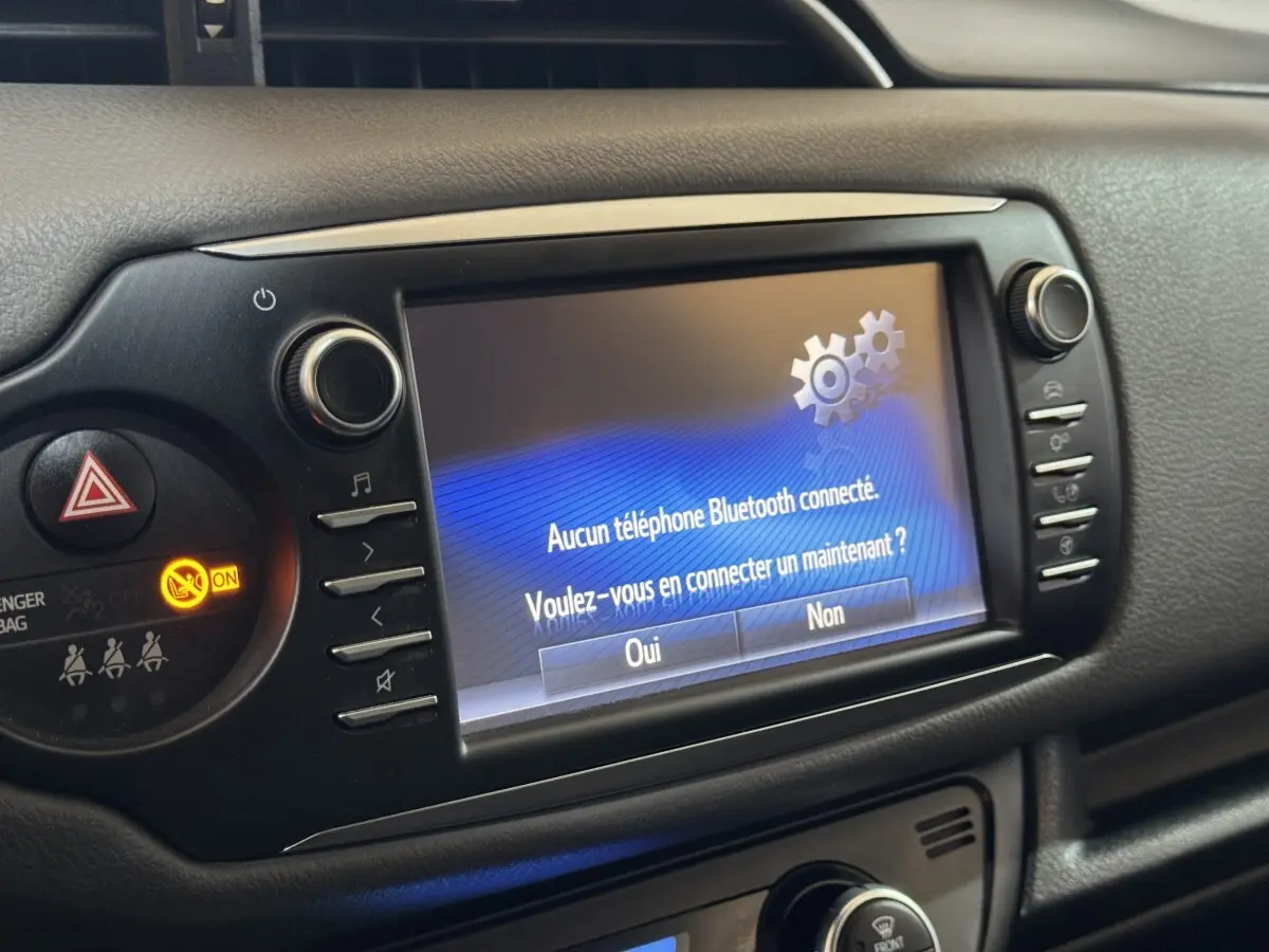 Écran tactile central de la Toyota Yaris 2019 affichant un message Bluetooth, vue rapprochée du tableau de bord noir.