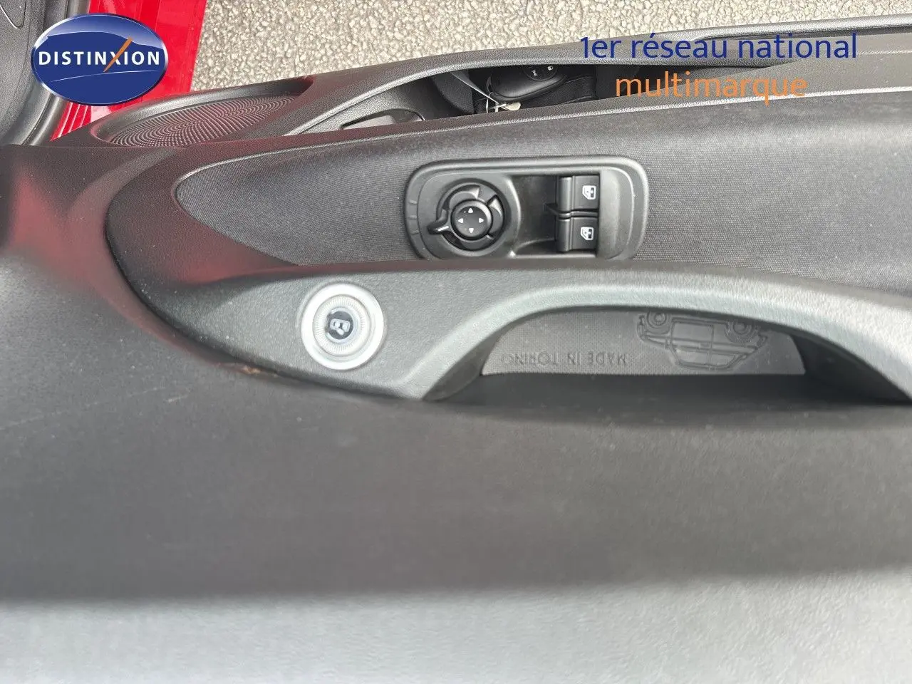 Détail de la commande des rétroviseurs et des vitres sur la porte côté conducteur d'une FIAT 500e rouge 2024.