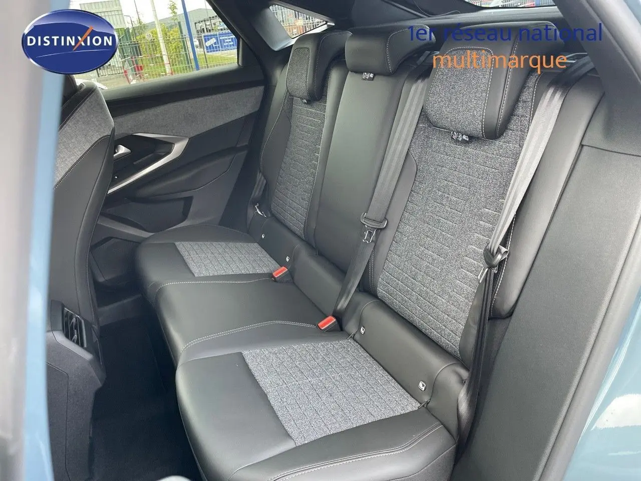 Vue intérieure sur les sièges arrière en cuir noir et tissu gris du Peugeot 3008 Hybrid 2025 bleu Ingaro Metal.