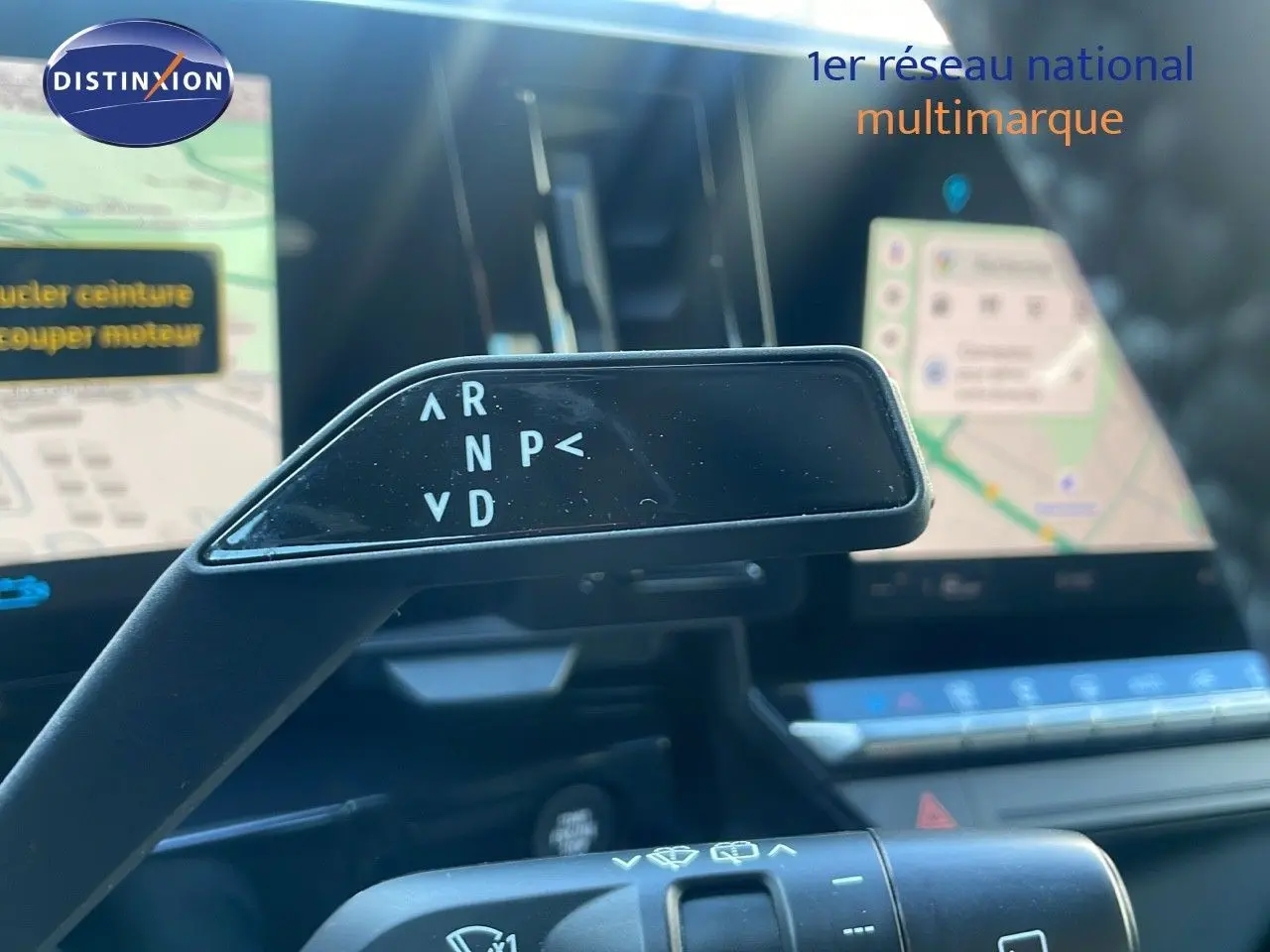 Le levier de vitesses automatique noir dans l'habitacle du Renault Austral blanc glacier, avec écran tactile en arrière-plan.