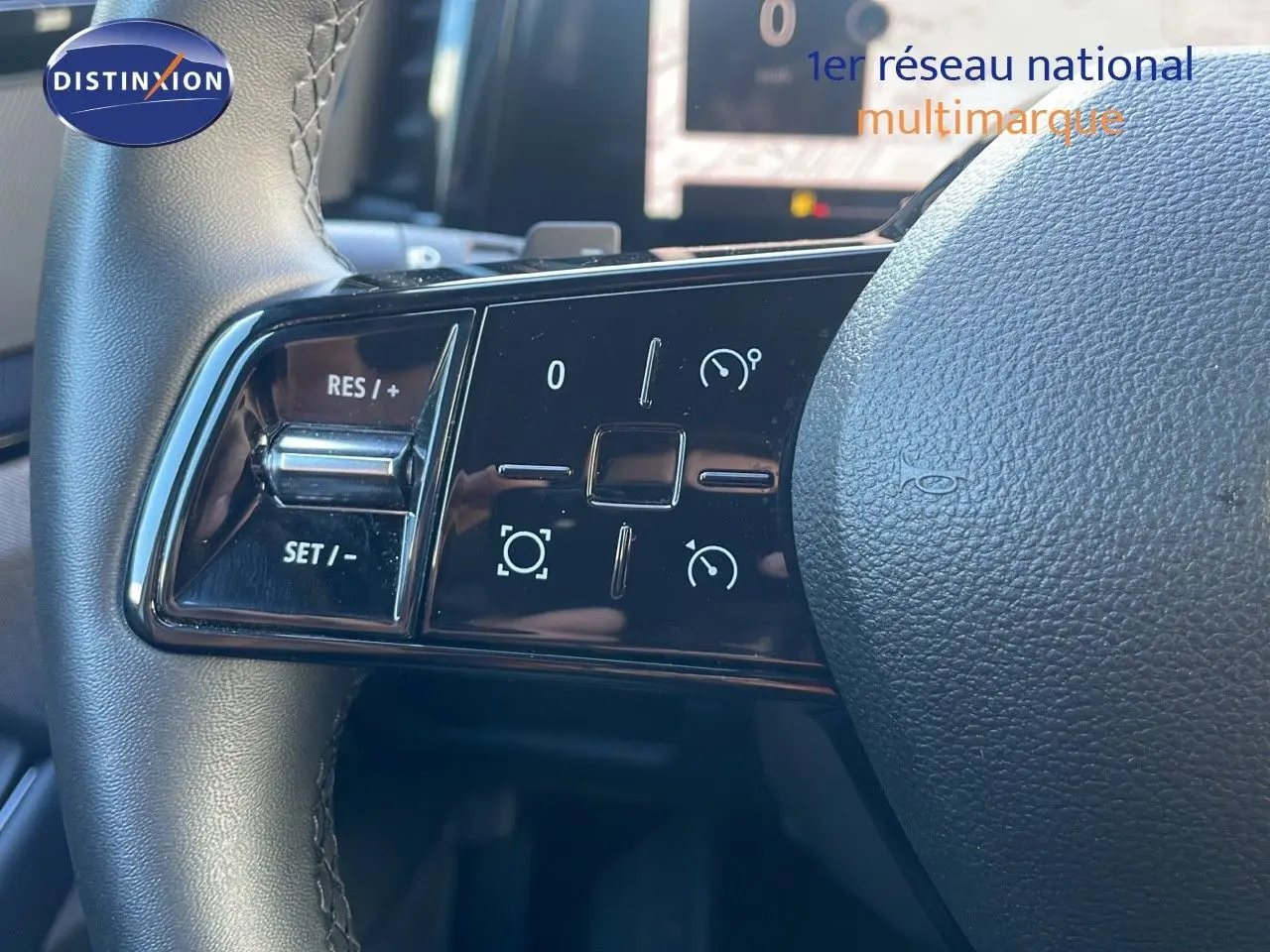 Gros plan sur les commandes à gauche du volant du Renault Austral 2023, finition hybride, avec boutons de régulateur de vitesse.