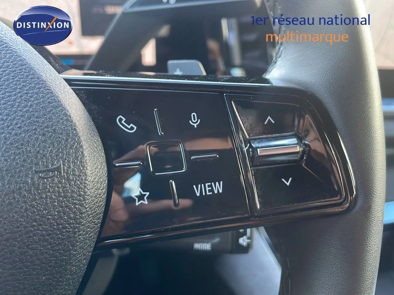 Gros plan sur les commandes du volant du Renault Austral blanc glacier, mettant en valeur les boutons multifonctions et le design moderne.