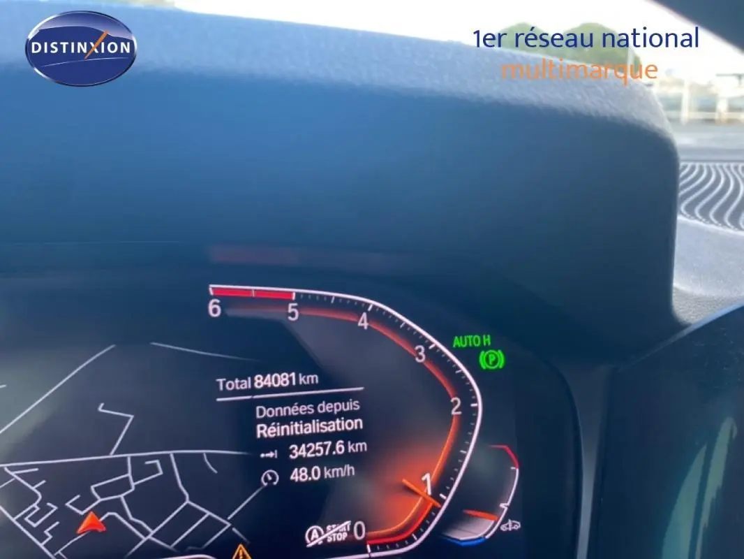 Tableau de bord numérique d'une BMW Série 3 G20 noire, affichant le compteur et la navigation.