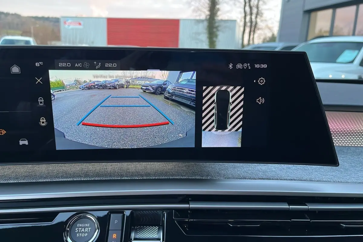 Vue intérieure sur l’écran de caméra de recul du Peugeot 5008 gris titane avec toit noir, affichage de guidage au stationnement.