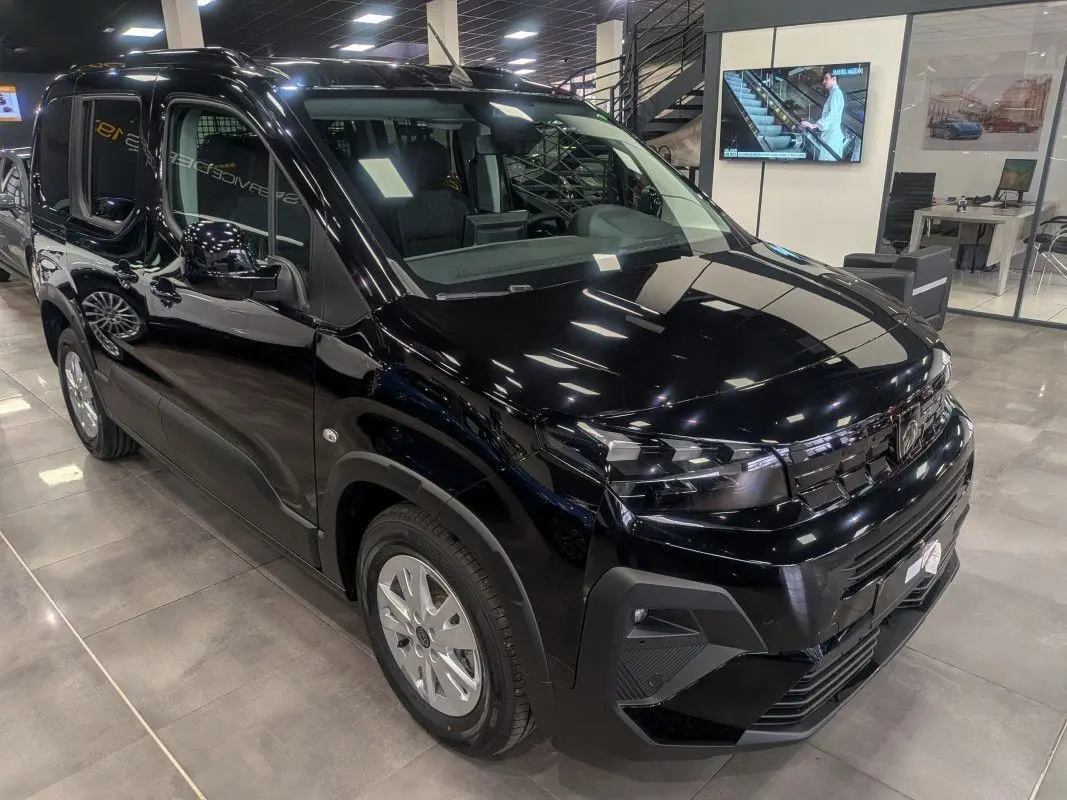 Peugeot Rifter Allure noir Perla Nera en 3/4 avant droit, avec calandre noire et jantes argentées en showroom.