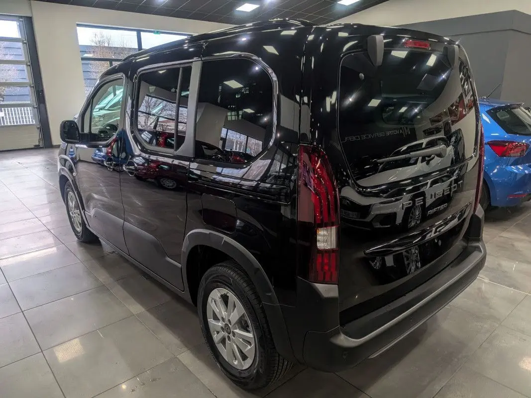 Vue 3/4 arrière droite d’un Peugeot Rifter noir Perla Nera brillant, avec feux arrière verticaux et jantes alliage.