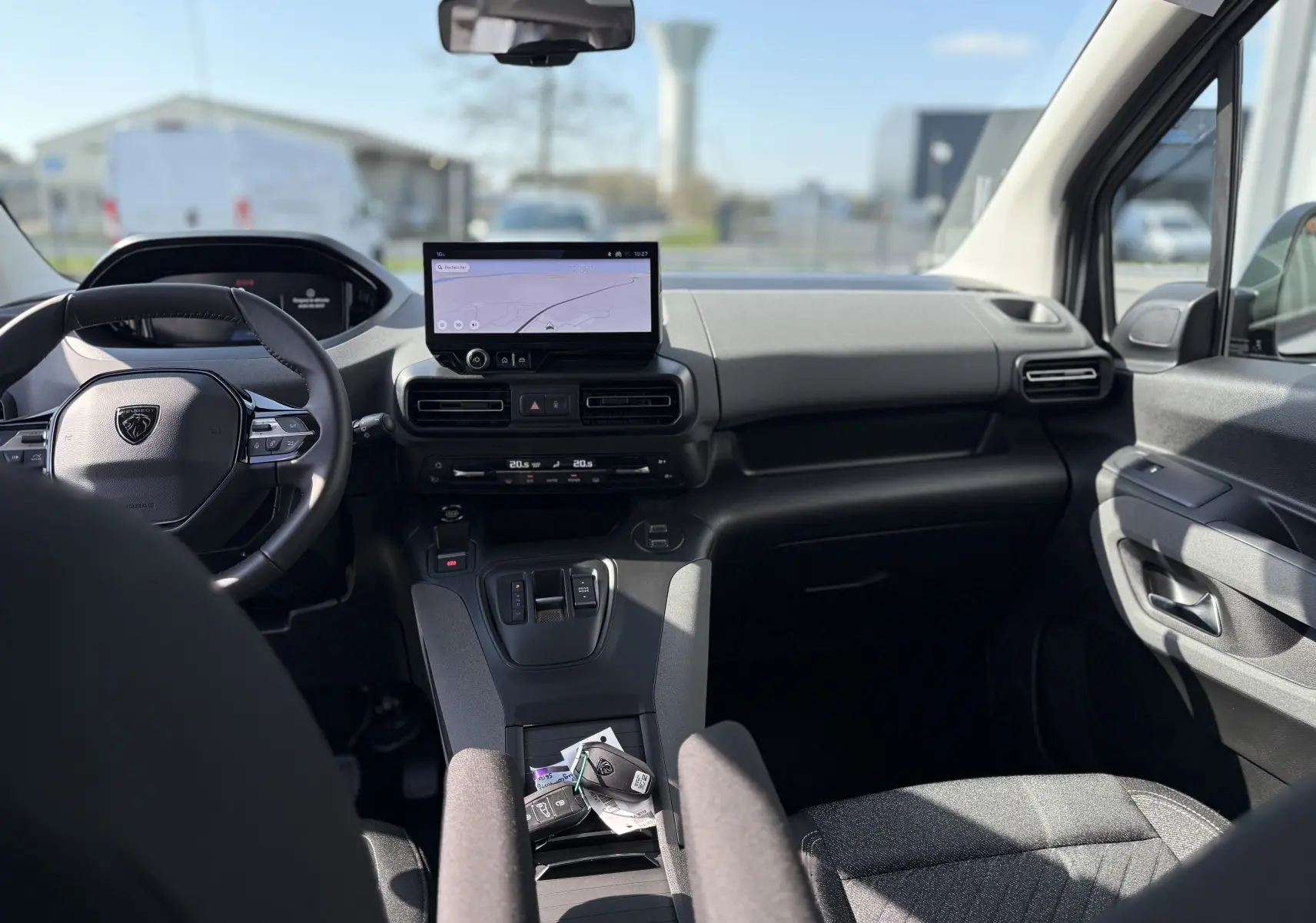 Intérieur noir du Peugeot Rifter Allure 2026 vu de face, avec tableau de bord moderne et écran tactile central.