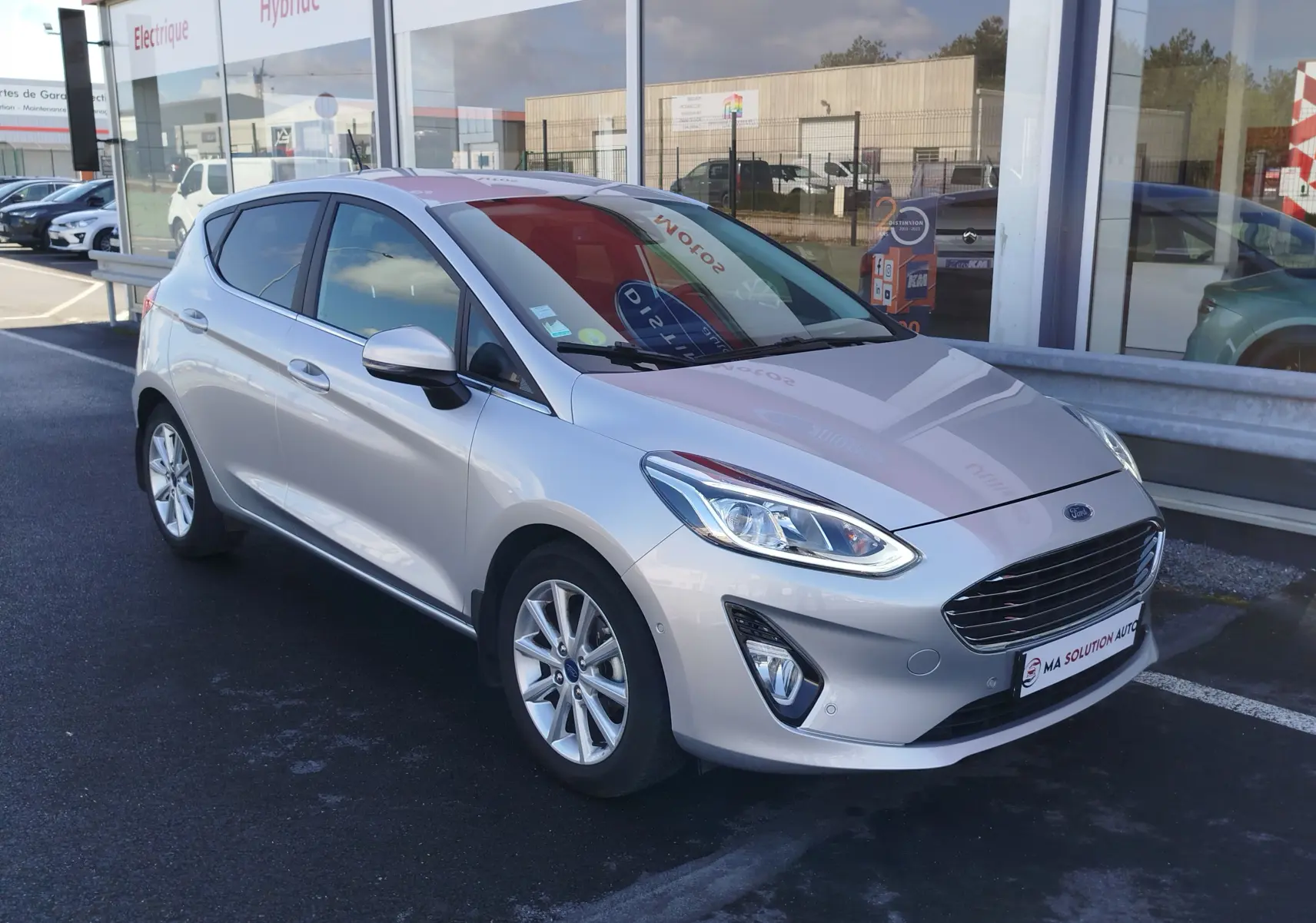Ford Fiesta gris lunaire vue en 3/4 avant droit, avec phares LED et jantes alliage 16 pouces visibles.