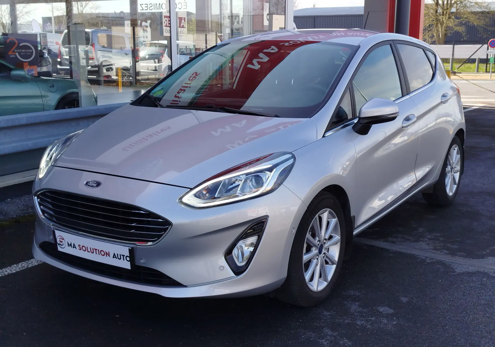 Vue 3/4 avant droite d'une Ford Fiesta gris lunaire 2019, avec calandre noire et jantes alliage.