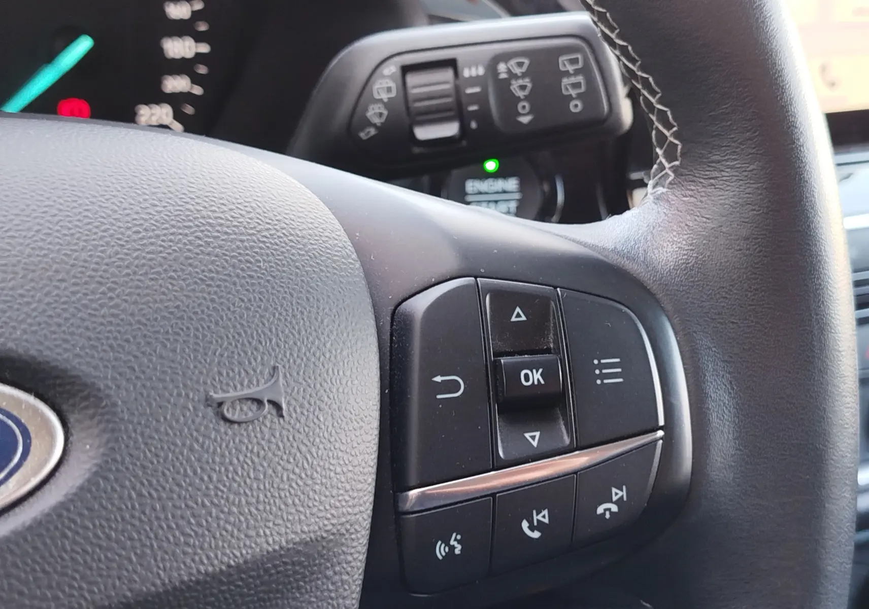 Gros plan sur le volant noir de la Ford Fiesta gris lunaire, avec commandes multifonctions visibles côté droit.