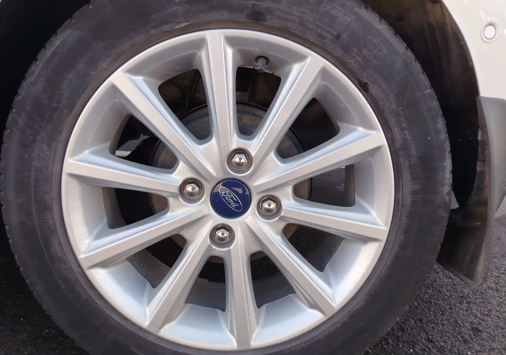 Gros plan sur la jante alliage argentée de la Ford Fiesta gris lunaire, avec logo Ford au centre.