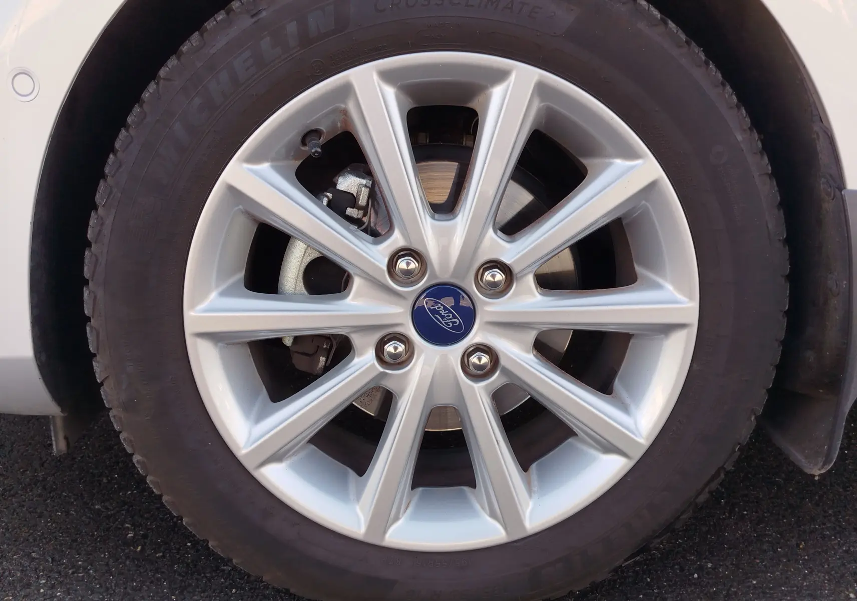 Gros plan sur la roue avant droite d'une Ford Fiesta gris lunaire de 2019 avec jante alliage argentée et logo Ford central.