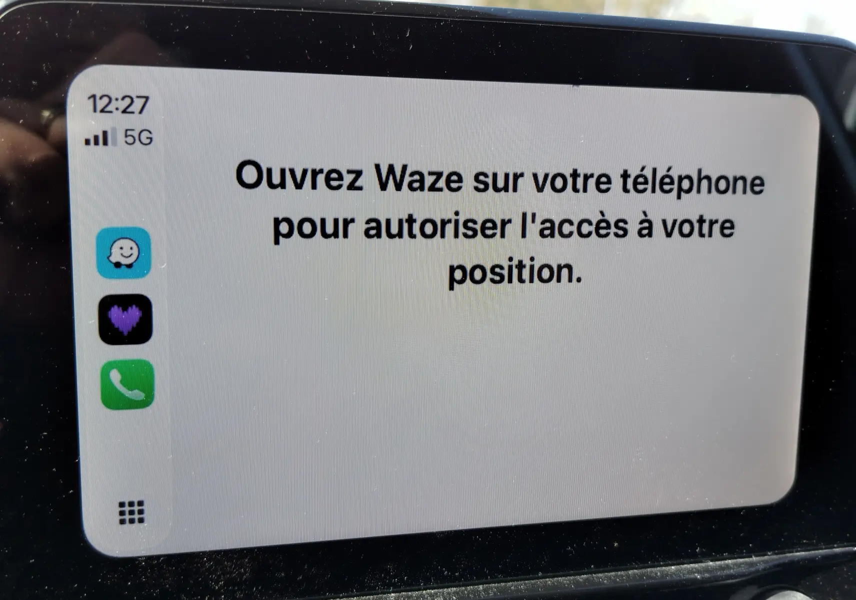 Écran tactile central affichant un message d'autorisation Waze dans une Ford Fiesta gris lunaire, vue rapprochée intérieure.
