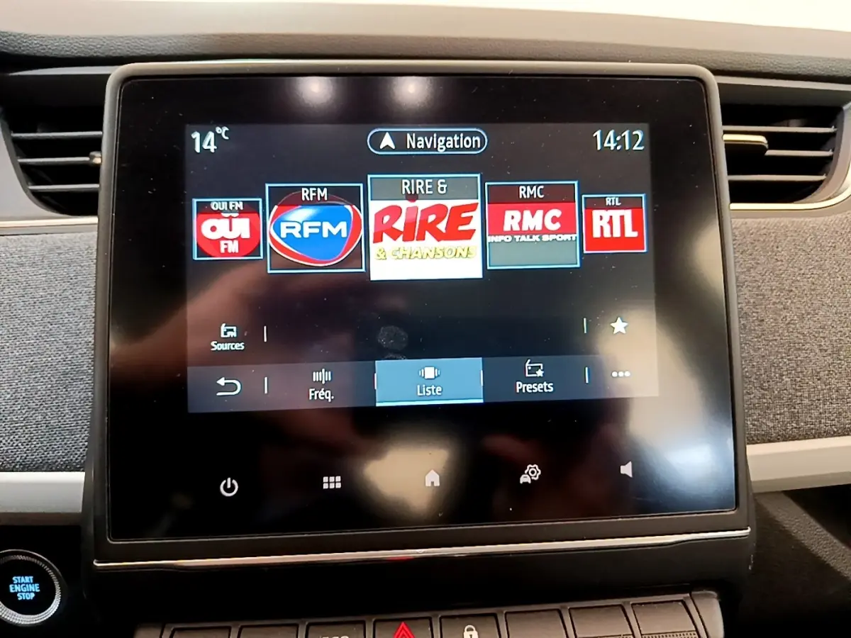 Écran tactile central de la Renault ZOE gris clair 2022 montrant les stations radio avec bouton démarrage visible.