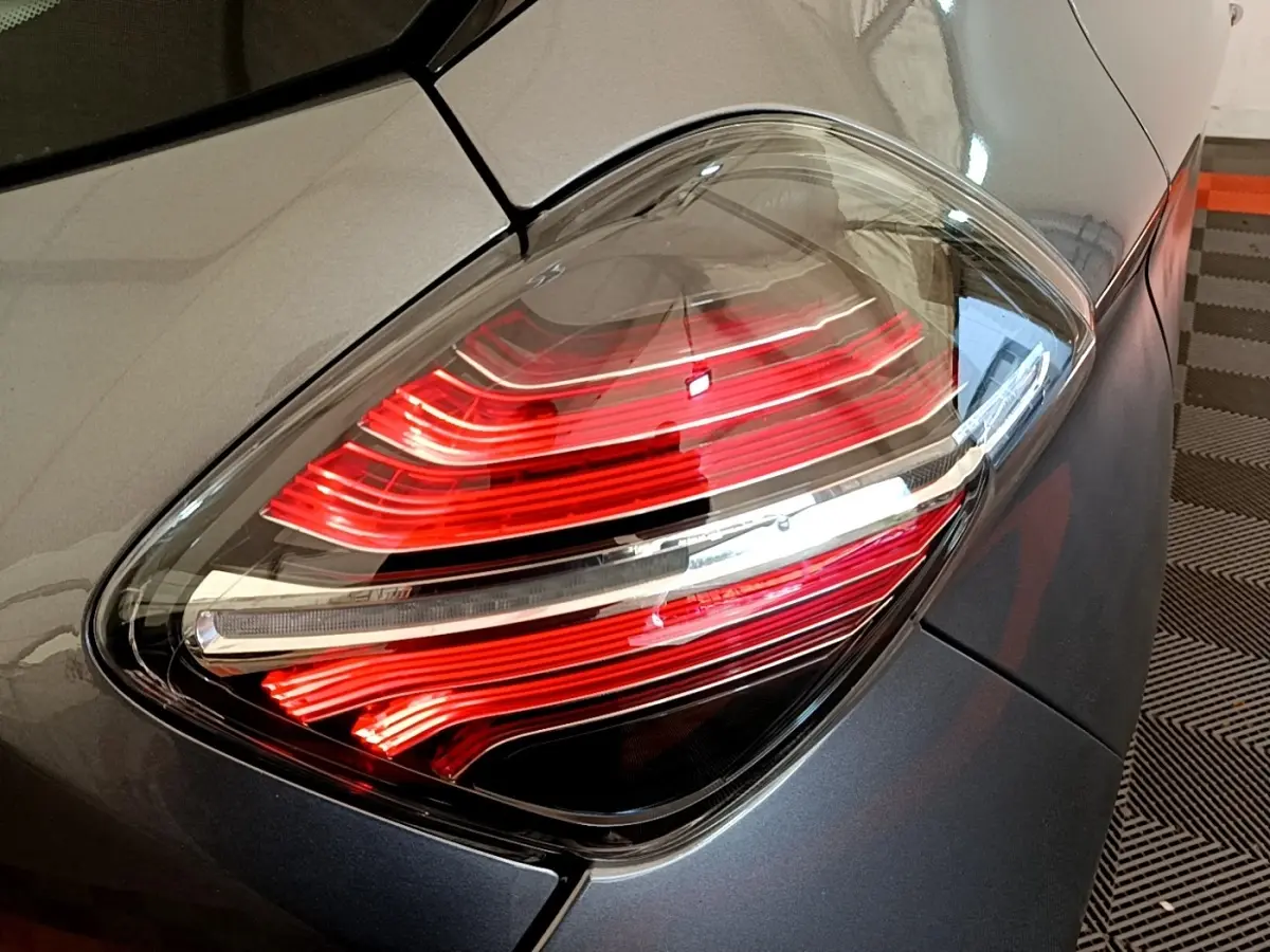 Gros plan sur le feu arrière droit rouge et blanc d'une Renault ZOE gris clair Evolution R110 2022.