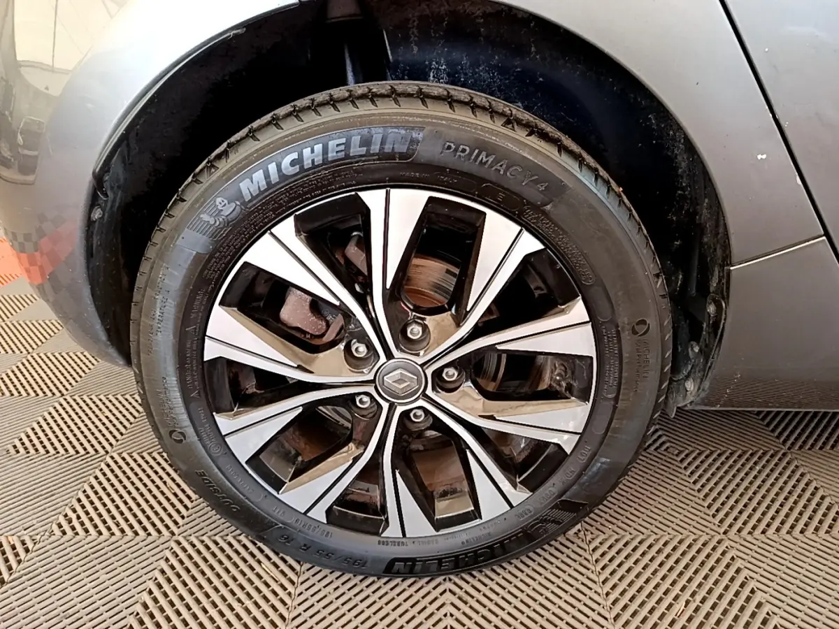 Vue rapprochée de la roue arrière droite d'une Renault ZOE gris clair sur sol à damier.