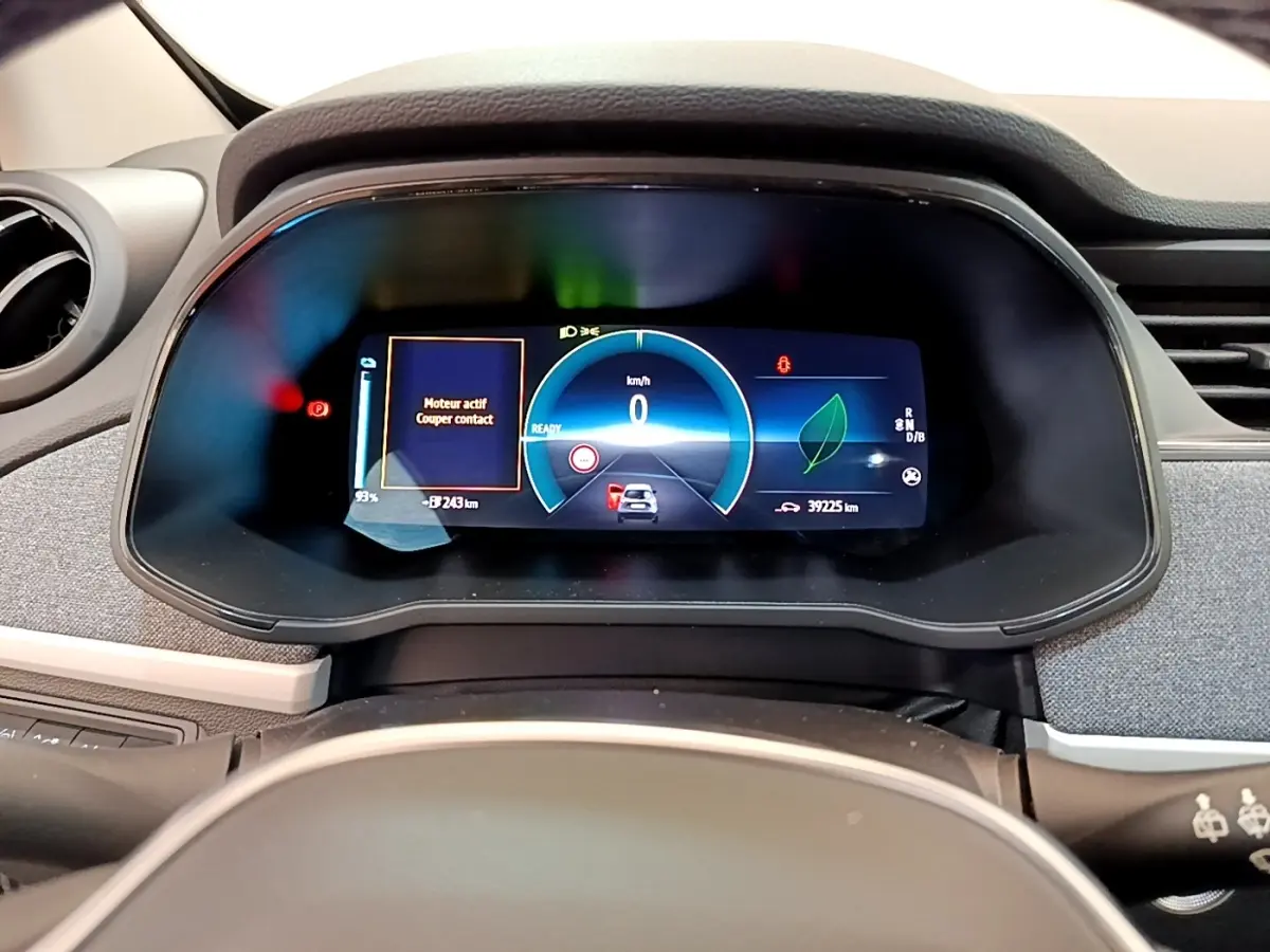 Vue rapprochée du combiné d'instruments numérique de la Renault ZOE gris clair, affichant la vitesse et l'autonomie électrique.