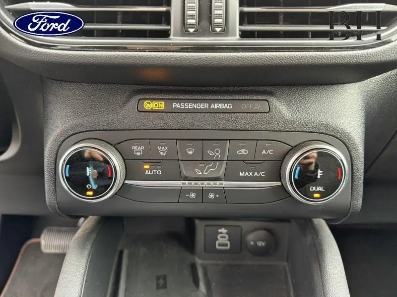 Vue rapprochée de la console centrale du Ford Kuga 2023, montrant les commandes de climatisation et l'écran tactile.