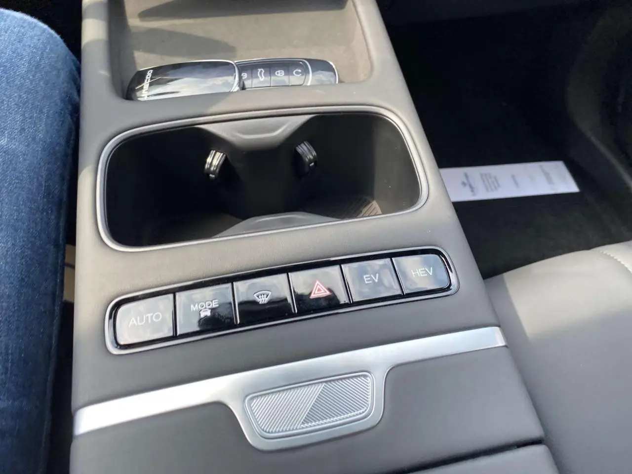 Vue rapprochée de la console centrale du JAECOO J7 2026, avec boutons de mode de conduite et porte-gobelets noirs.