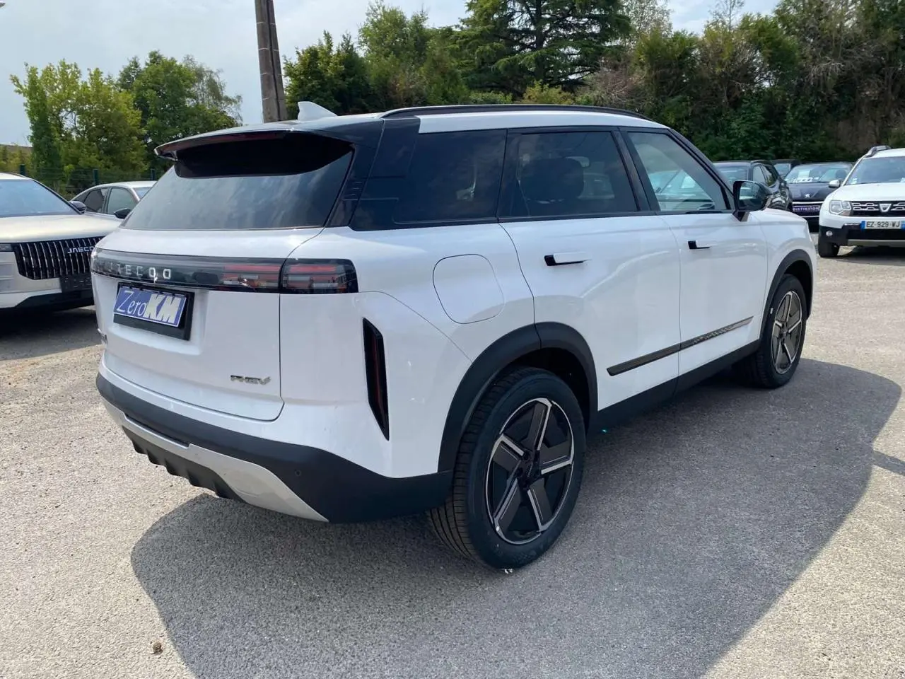 SUV JAECOO J7 blanc khaki vu en 3/4 arrière droit, avec toit noir et feux arrière horizontaux fins.