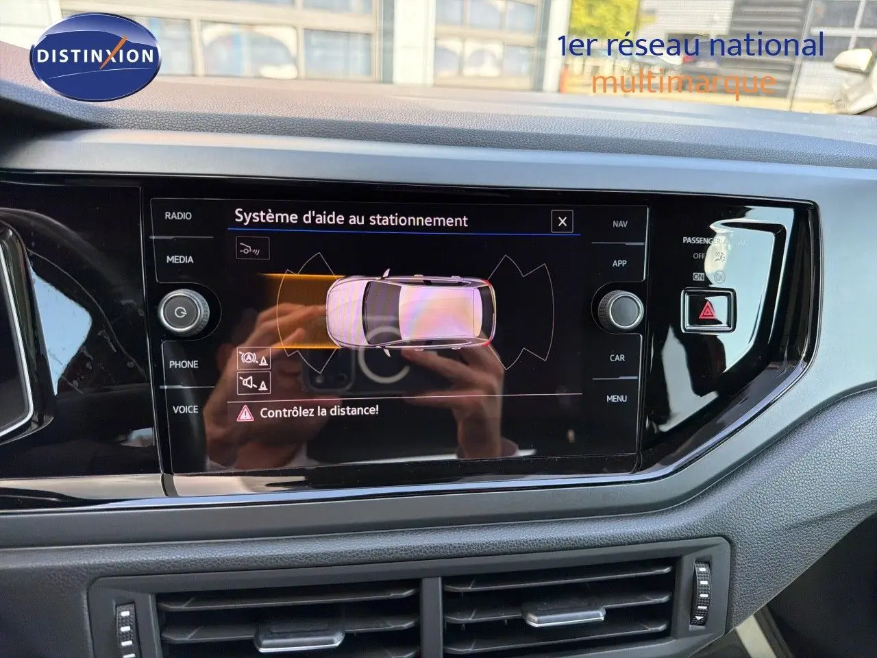 Vue rapprochée de l'écran tactile intérieur affichant le système d'aide au stationnement d'une Volkswagen Polo 2023.