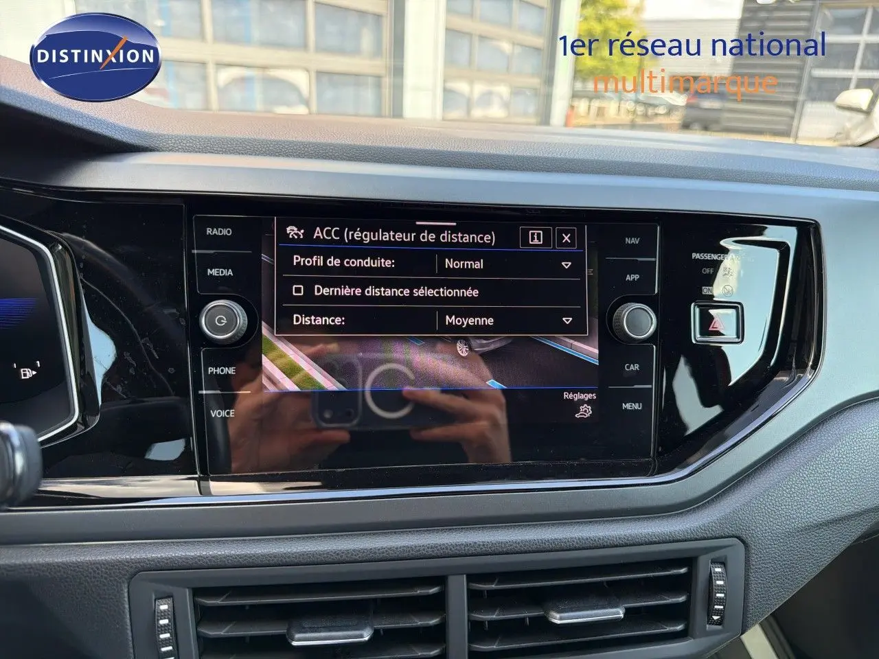 Vue rapprochée de l’écran tactile central de la Volkswagen Polo rouge Roi 2023, affichant le régulateur de distance ACC.