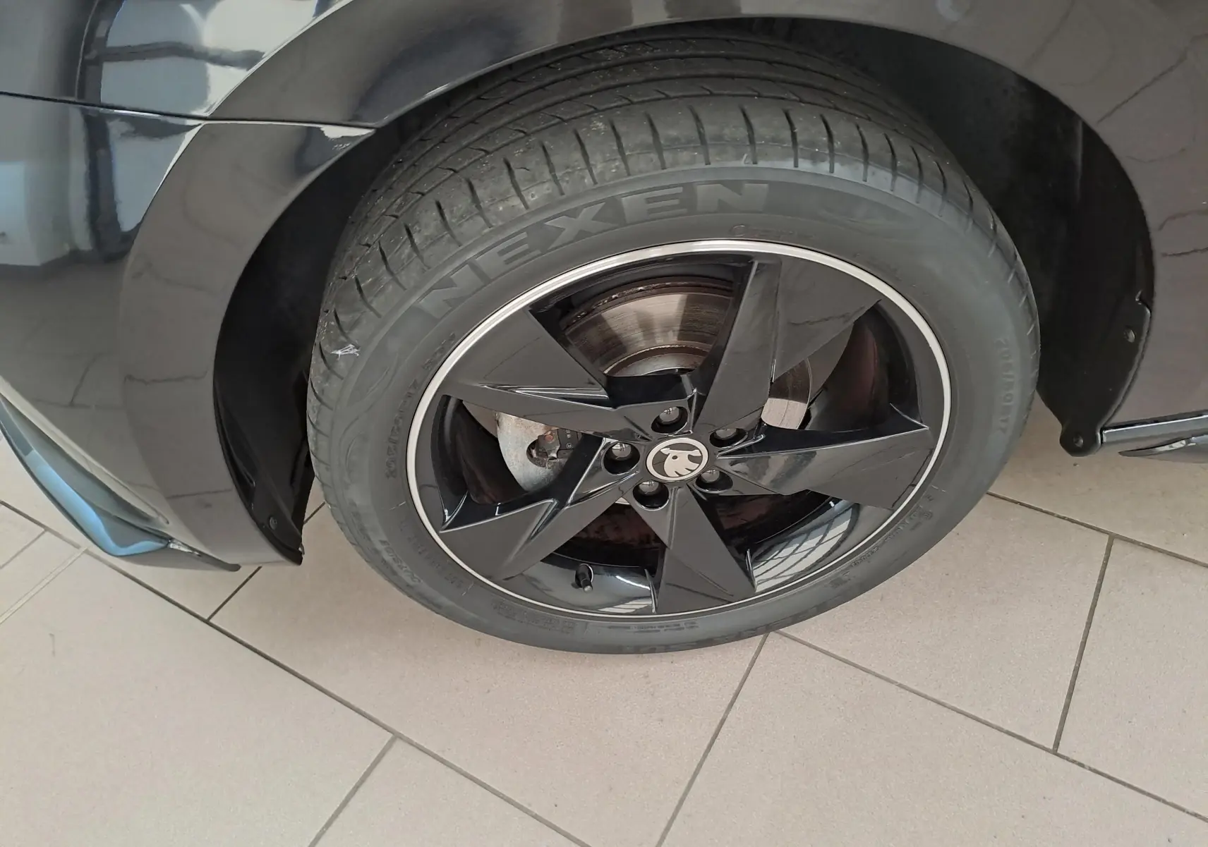 Gros plan sur la roue avant droite noire avec jante noire brillante de la Skoda Scala Monte-Carlo 2022.