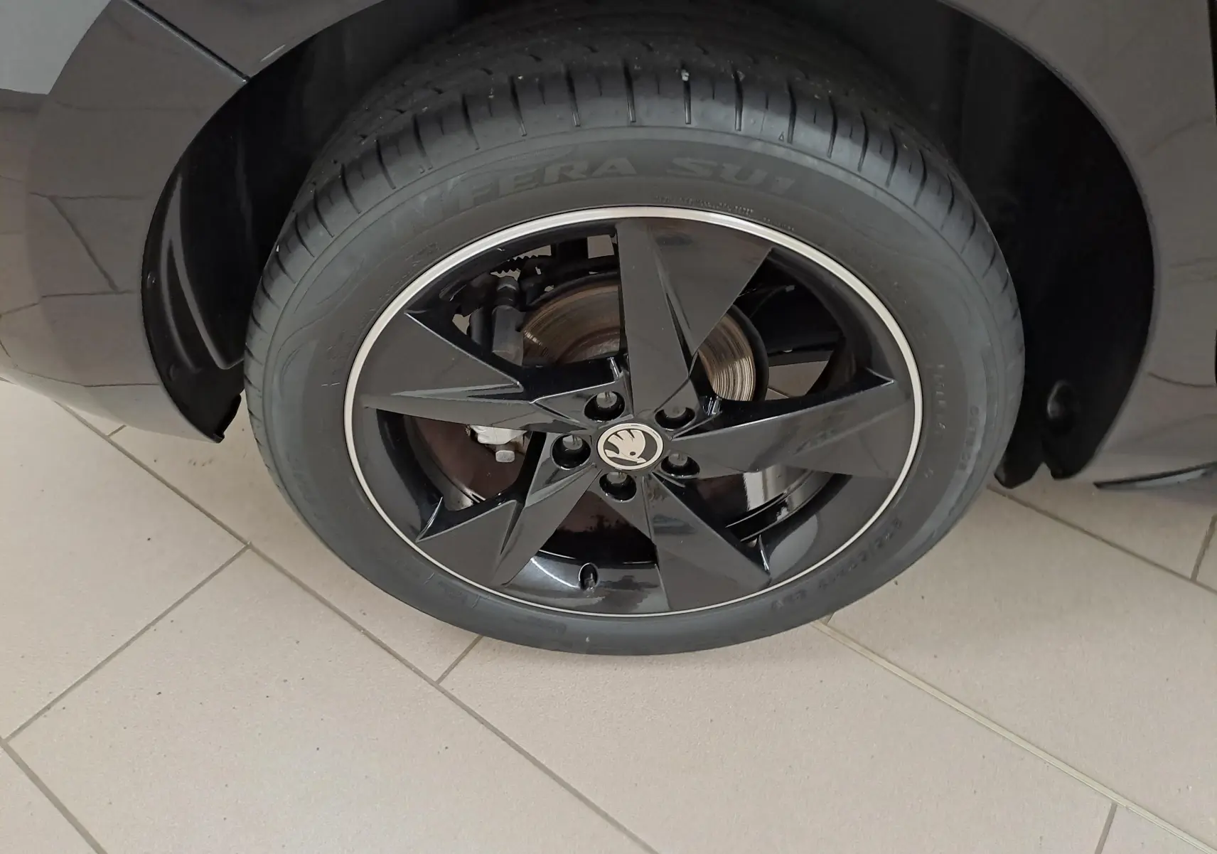 Gros plan sur la roue avant gauche noire brillante avec jante étoile et logo SKODA sur une SKODA SCALA Monte-Carlo 2022.