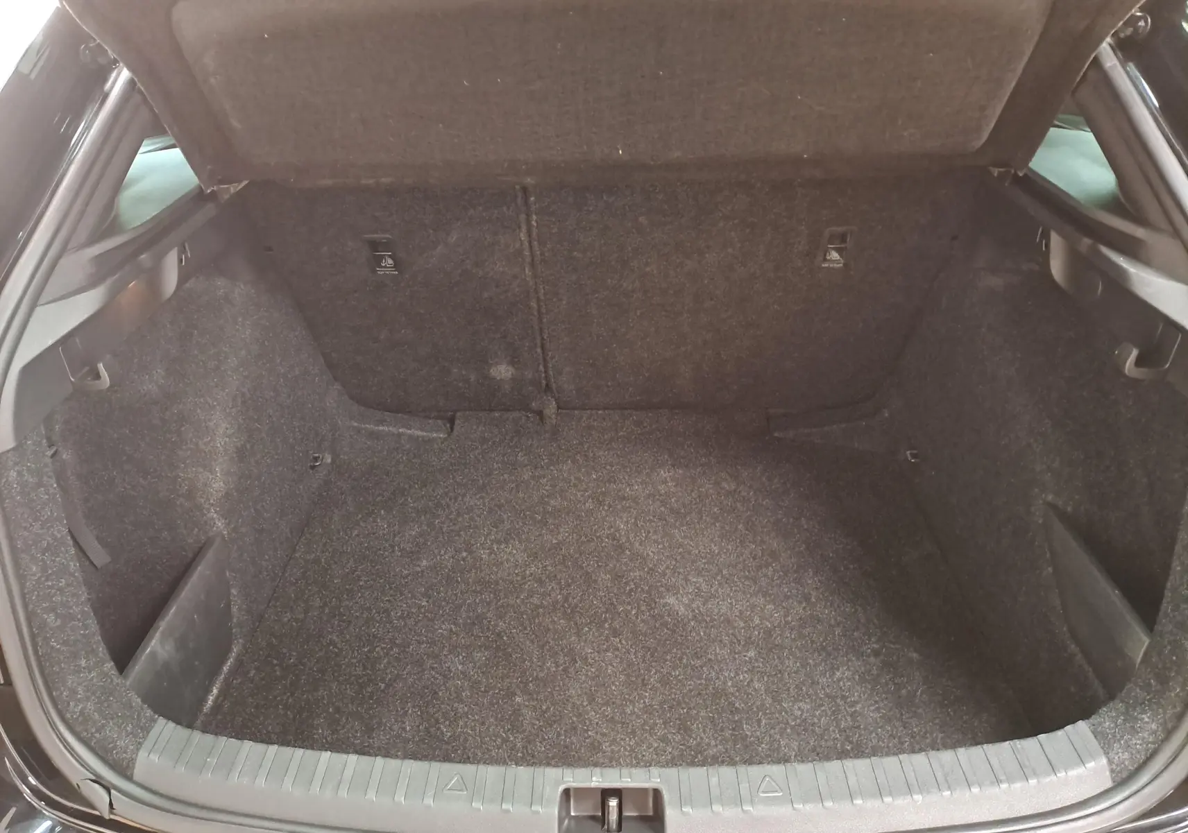 Coffre ouvert d'une Skoda Scala 1.0 TSI 110 DSG7 Monte-Carlo noir Magic nacré, vue intérieure arrière.