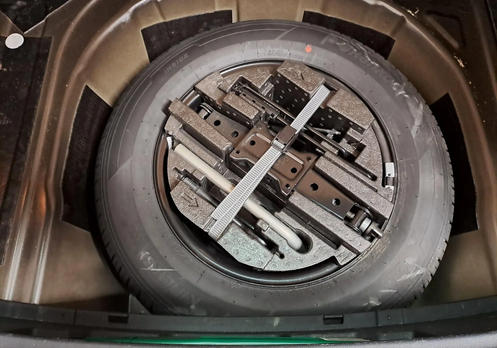 Roue de secours avec outils de bord rangés dans le coffre d'une Skoda Scala 2022 noir nacré.