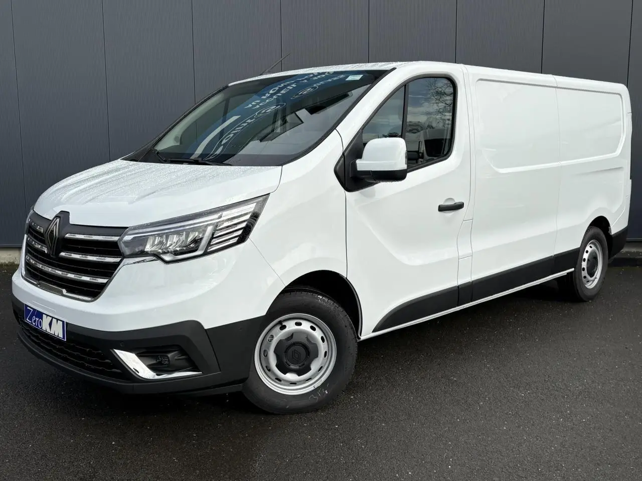 Renault Trafic Fourgon blanc glacier en 3/4 avant droit, avec calandre chromée et jantes acier simples.
