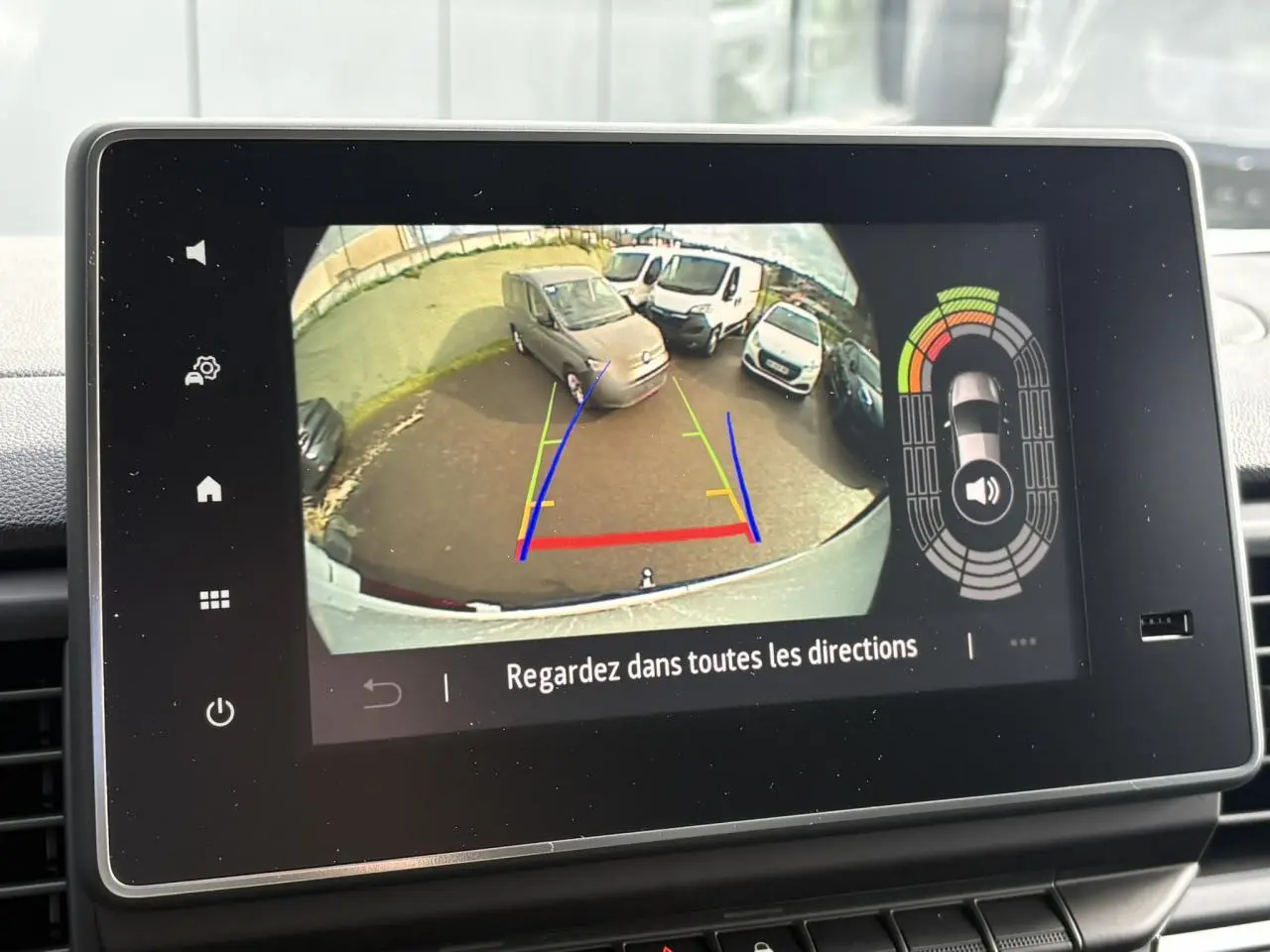 Vue caméra de recul montrant plusieurs véhicules blancs, dont un Renault Trafic Fourgon blanc en 3/4 arrière.