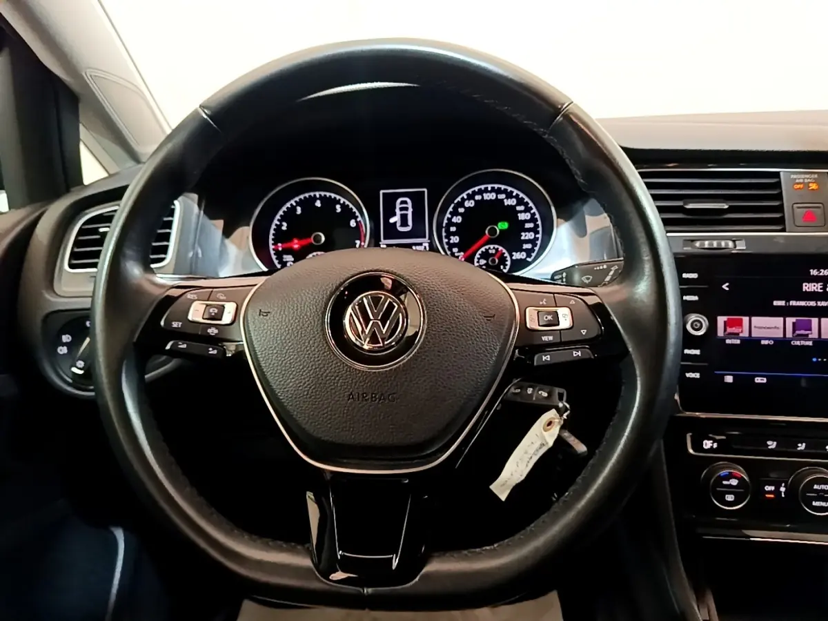 Vue rapprochée du volant cuir multifonctions noir de la Volkswagen Golf 2019 avec tableau de bord et écran tactile visible.