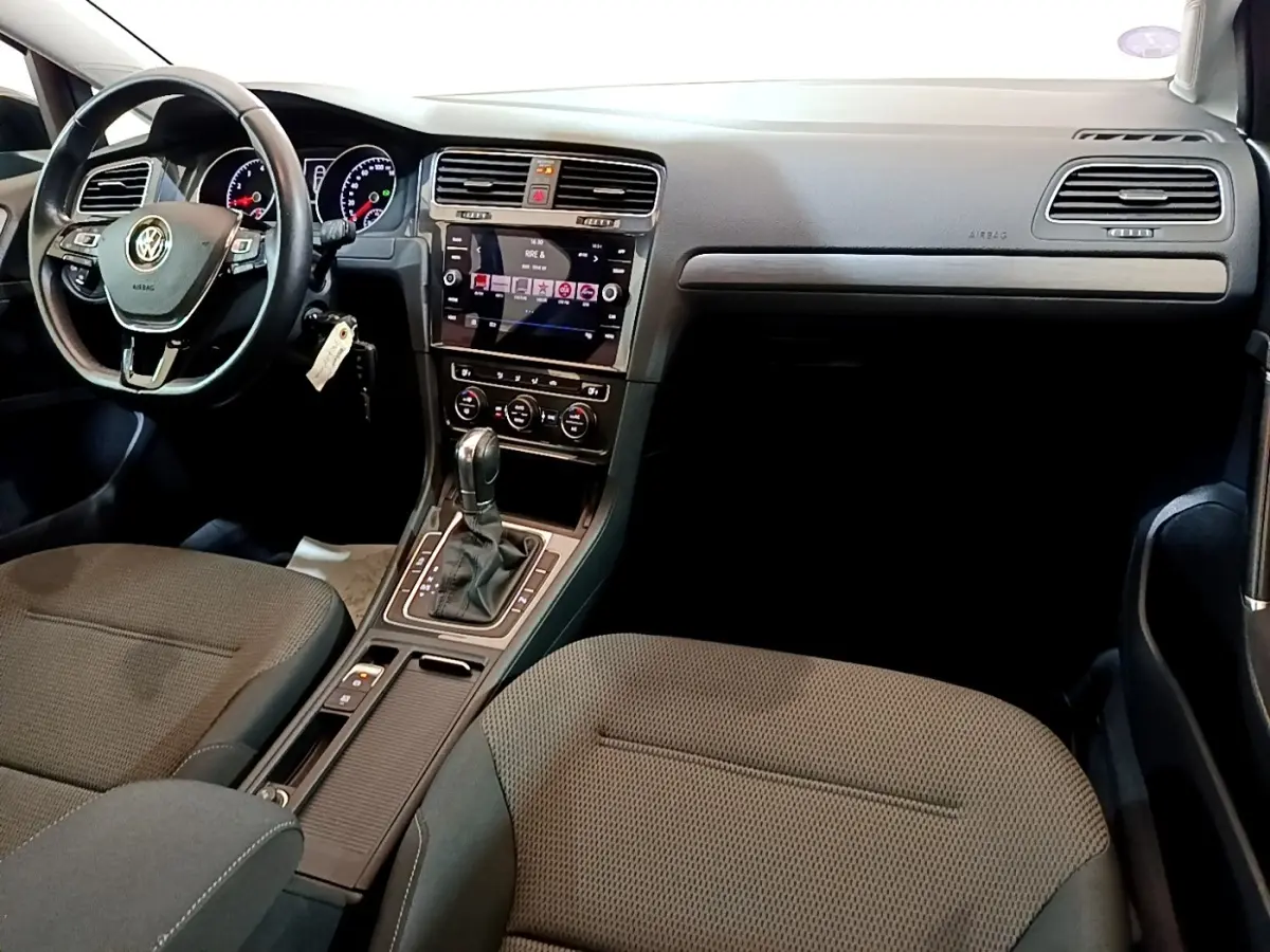 Vue intérieure avant droite de la Volkswagen Golf noire 2019, avec tableau de bord moderne et volant cuir multifonctions.