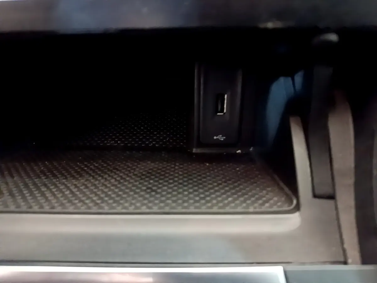 Gros plan sur la prise USB dans le compartiment de rangement intérieur de la Volkswagen Golf noire.