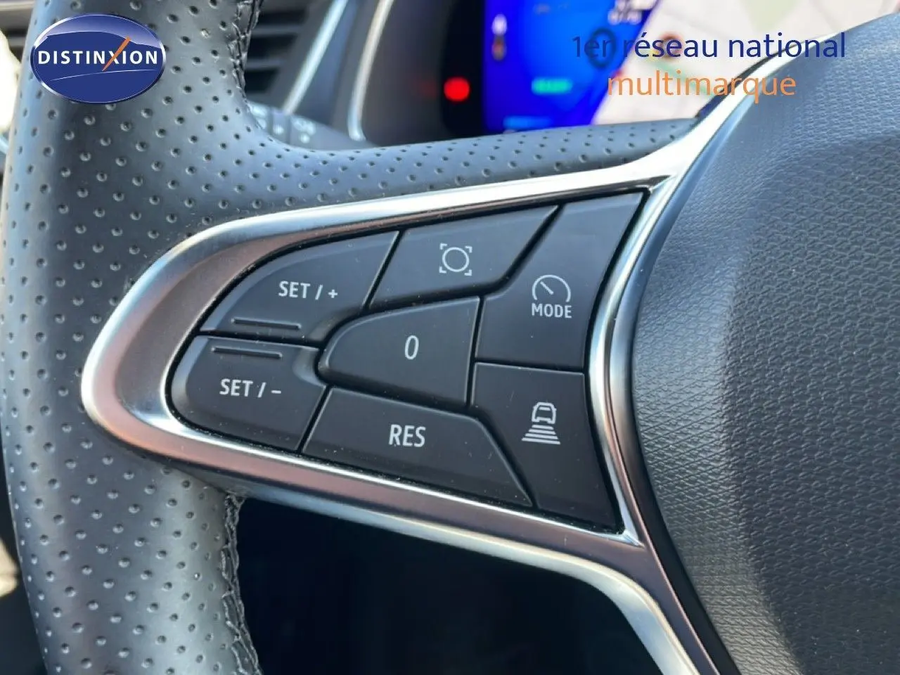 Gros plan sur les commandes de régulateur de vitesse au volant cuir perforé du Renault Symbioz noir étoile métal.