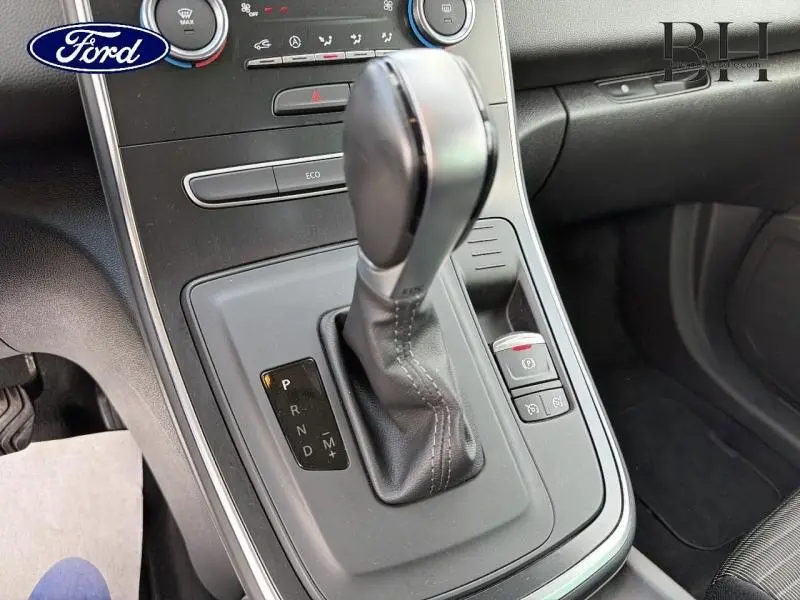 Gros plan sur la console centrale avec levier de vitesses automatique du Renault Grand Scenic gris Cassiopée, intérieur noir.
